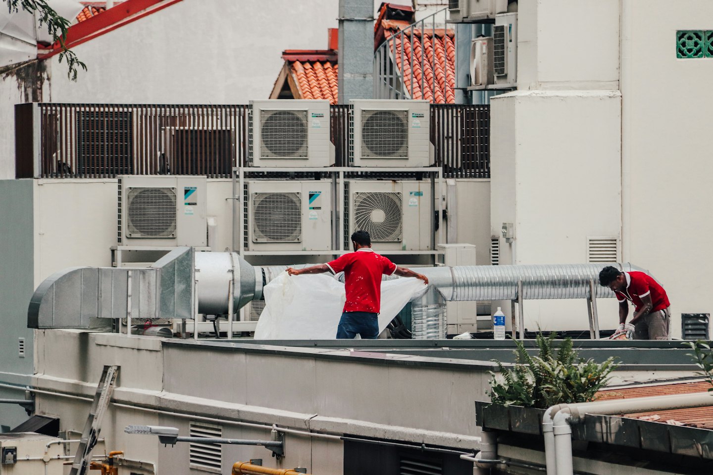 HVAC technicians working on rooftop air conditioning units.